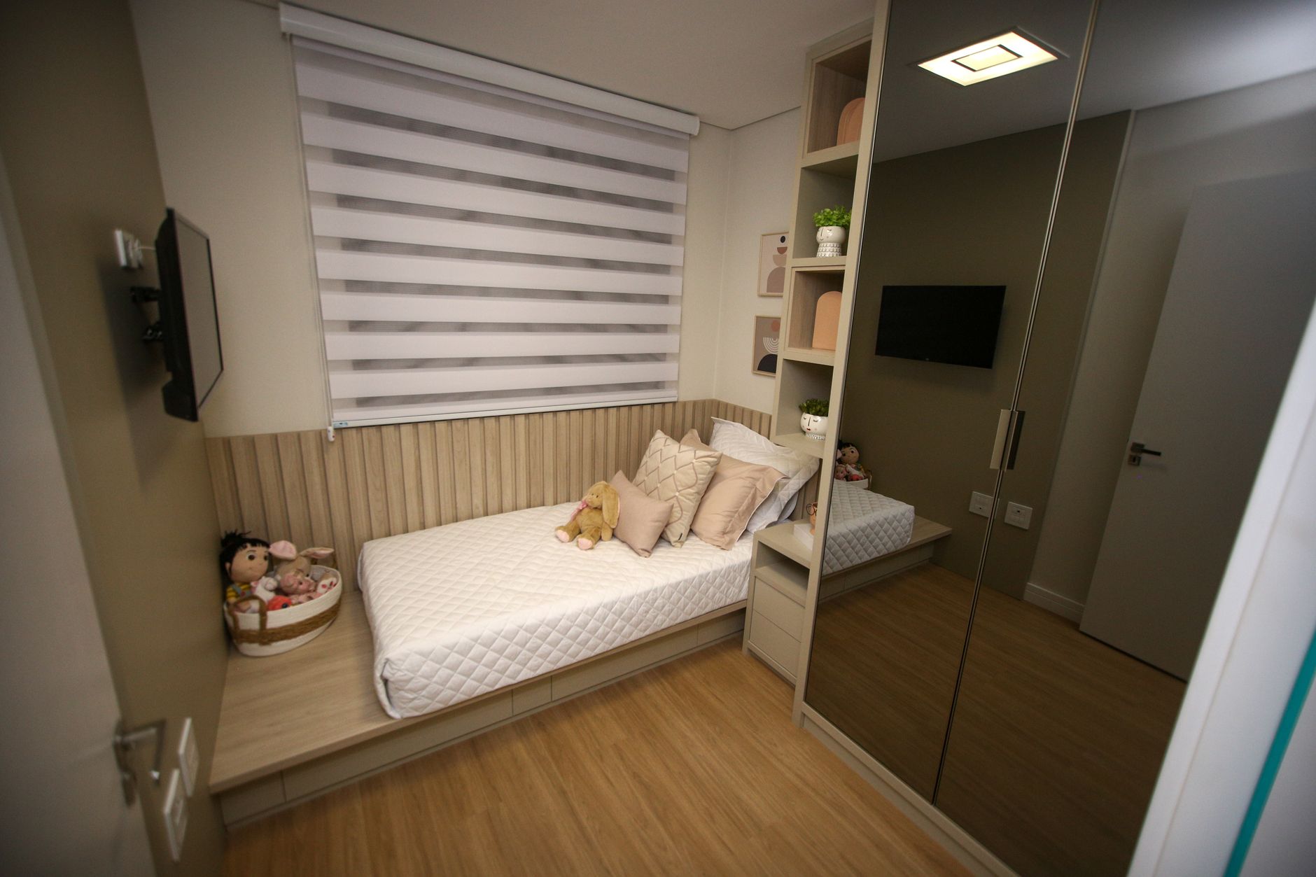 Een kinderkamer met opgeruimde speelgoedopslag en een gezellig speelhoekje.